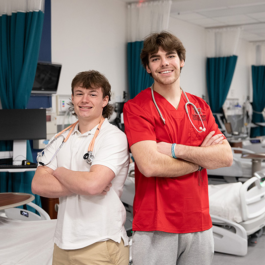 two nursing students standing back to back