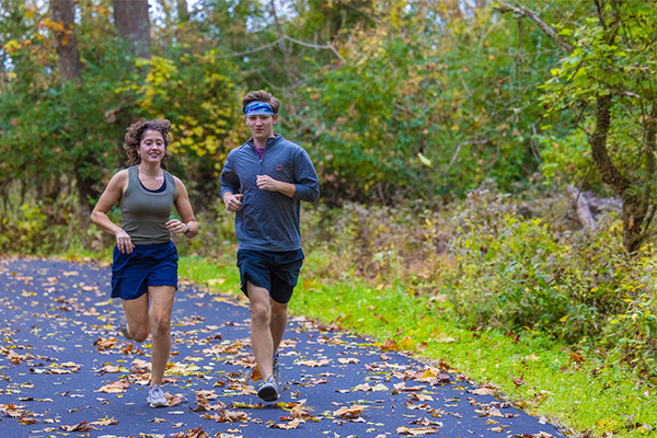 two students jogging on a trail in the natural areas