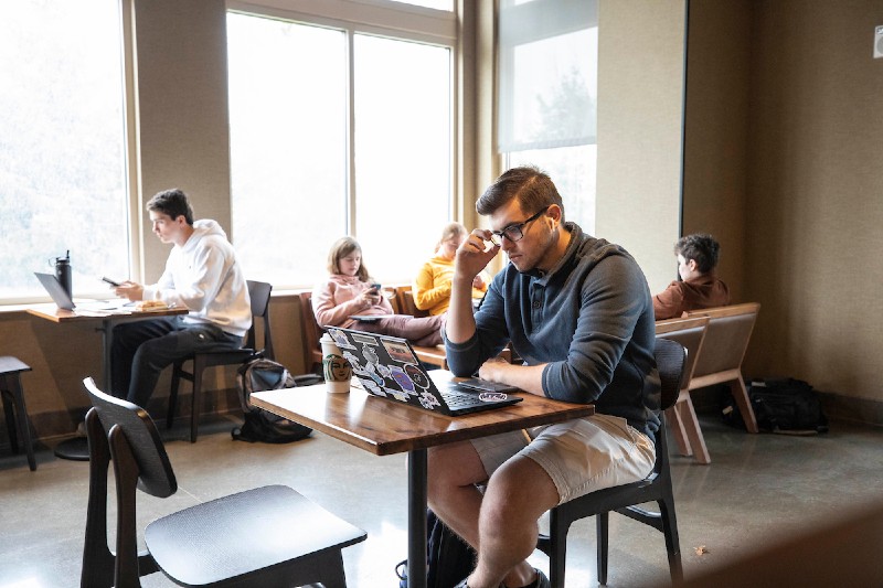 A Miami student doing coursework from a coffee shop