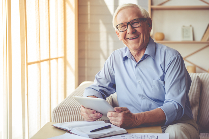 An older adult taking an online class from his home