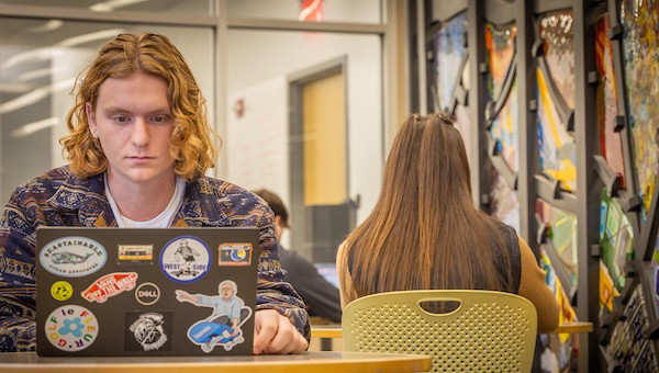 student working on their laptop in a library