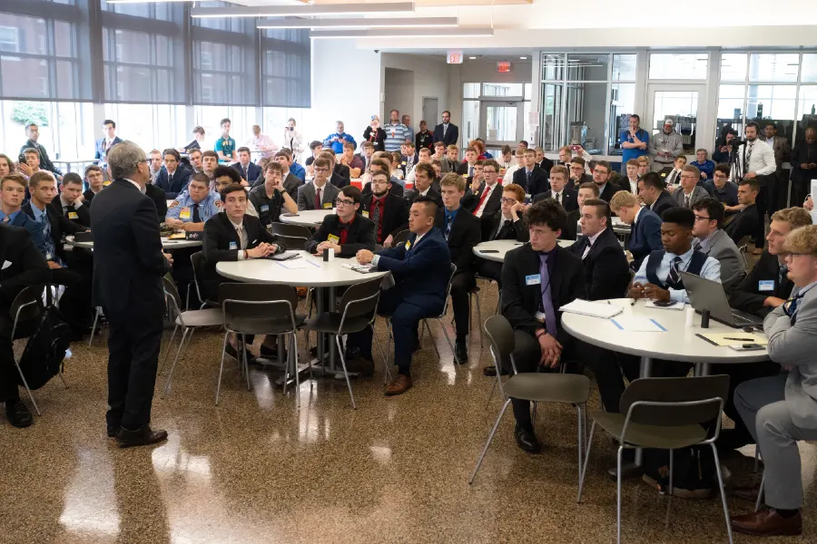 Group sitting at tables watching presentation.