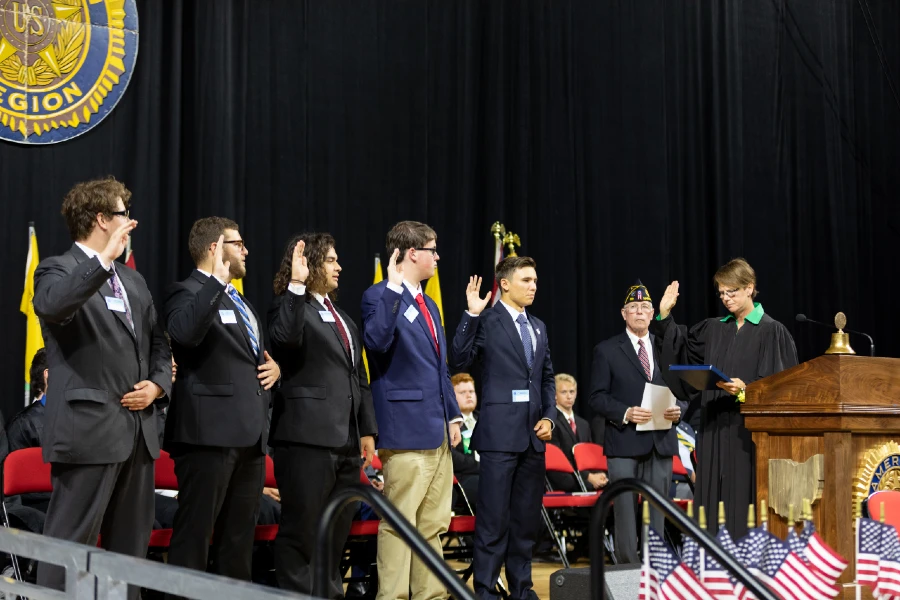 Buckeye Boys attendees on stage taking oath with American Legion leader and judge.