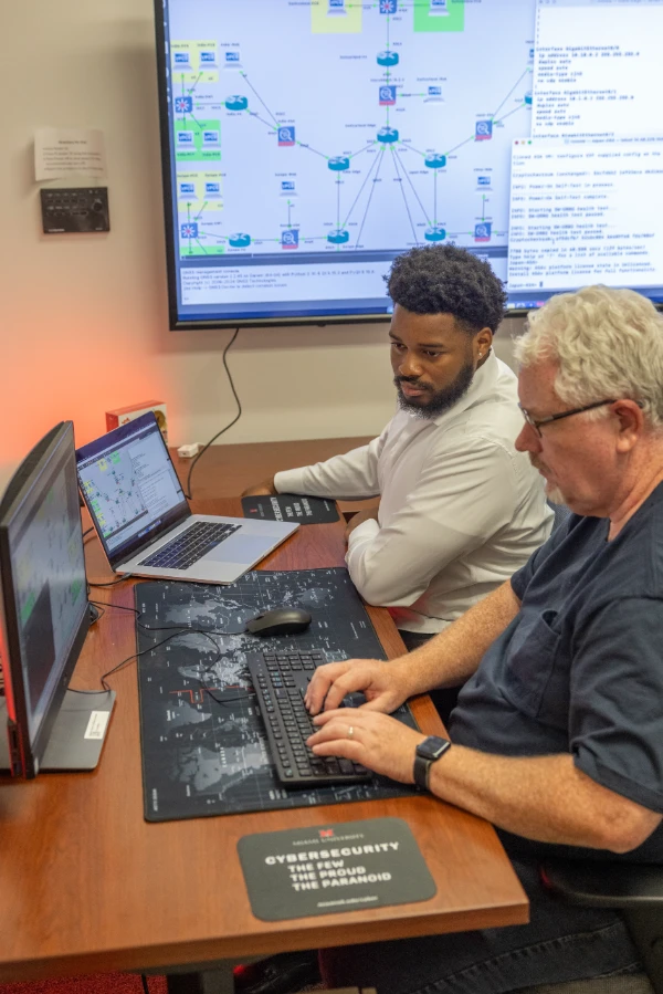 people working on multiple computer screens