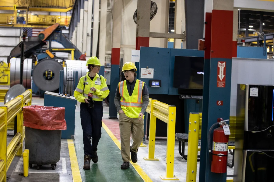 people walking through a factory with safety gear on