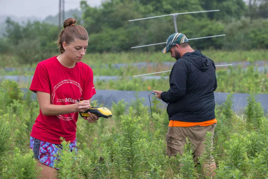 students reading devices in a field