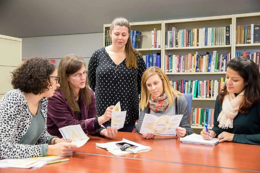 students and faculty talking at a table