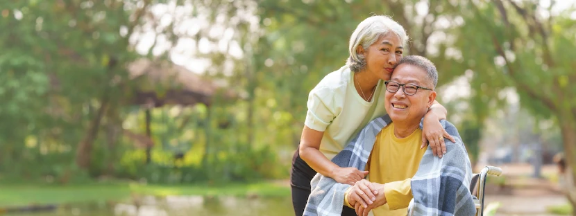 a woman hugging an older man in a wheelchair