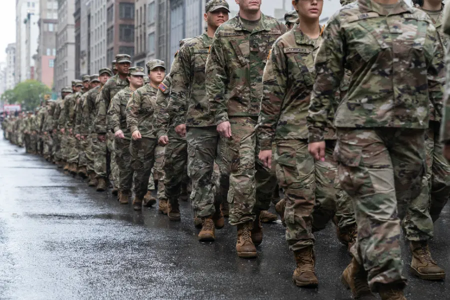 National Guard troops marching in line formation on street.