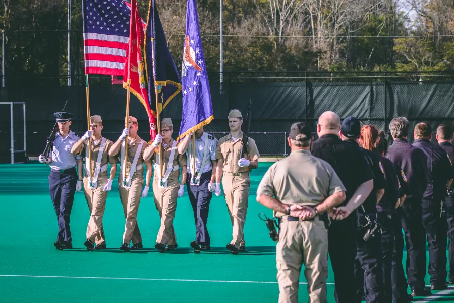 Soldiers presenting flags on field.