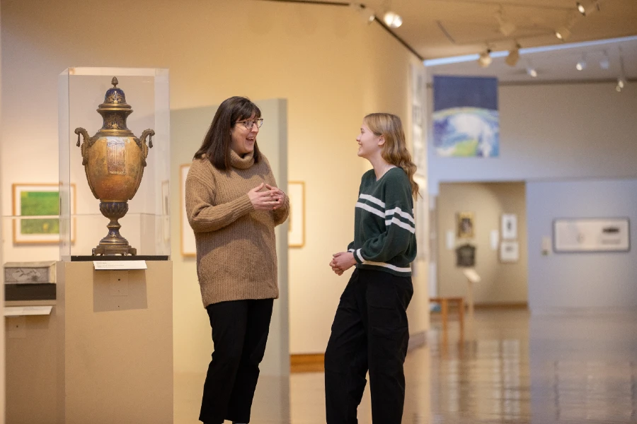 a student talking with someone in the art center about their work