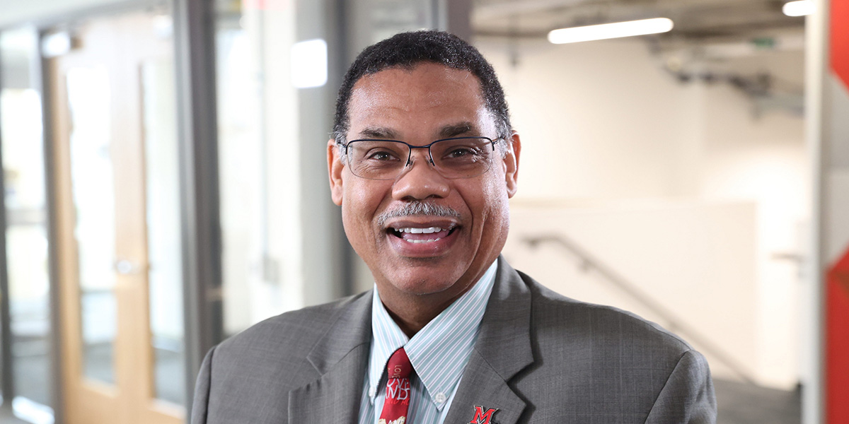 Vice President of ASPIRE Randi Thomas wearing a gray suit and red Miami tie