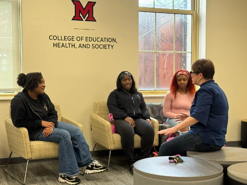 people sitting and talking in a common area at the college of education health and society