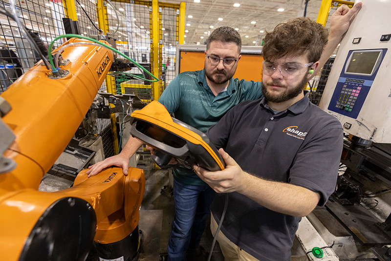 Two men working on mechanical equipment