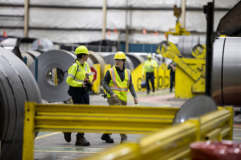two people walking around in an industrial building