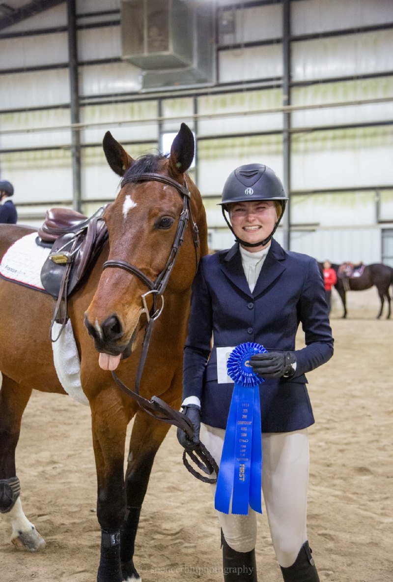Annika Nyberg with her horse holding a first place ribbon