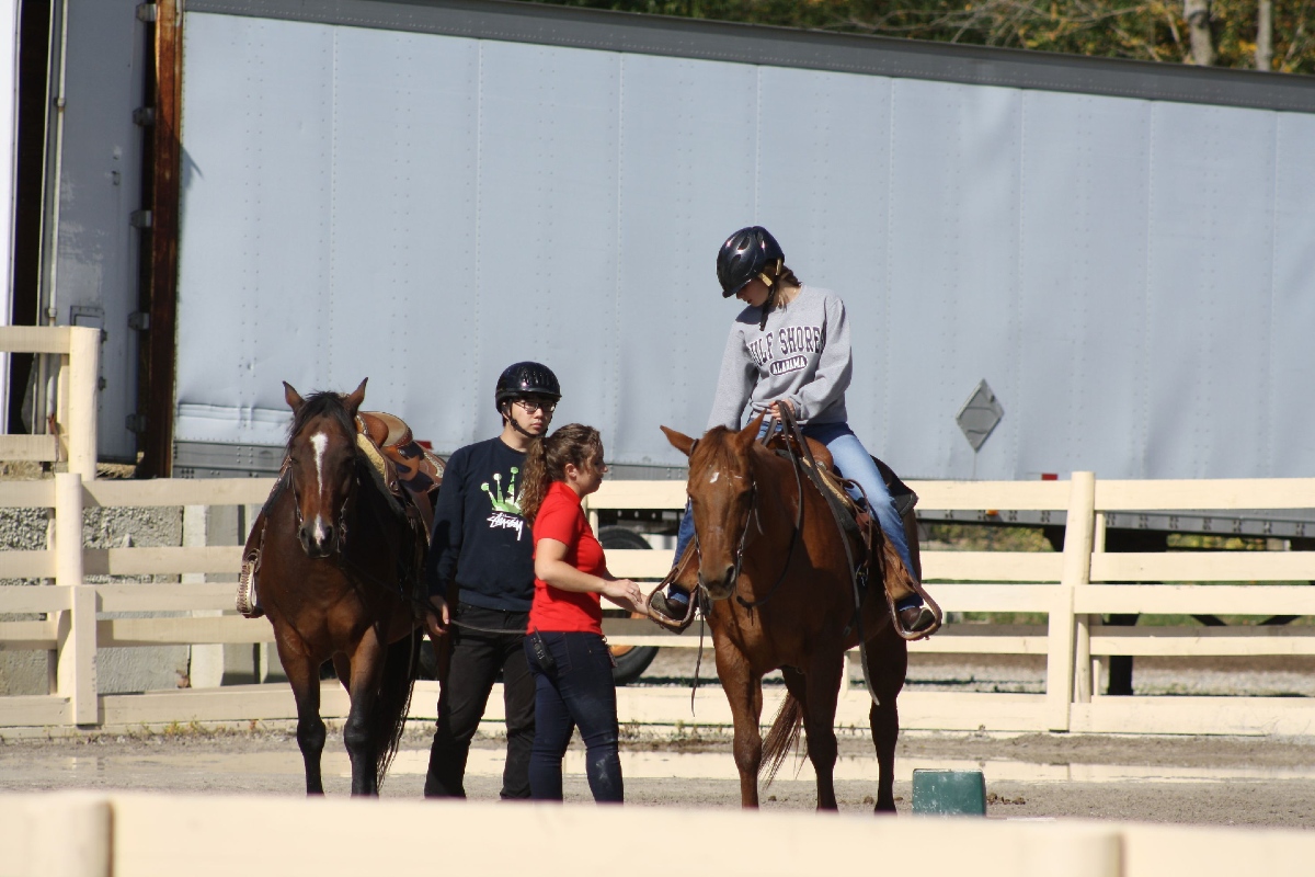 Miami students riding horses around the paddock