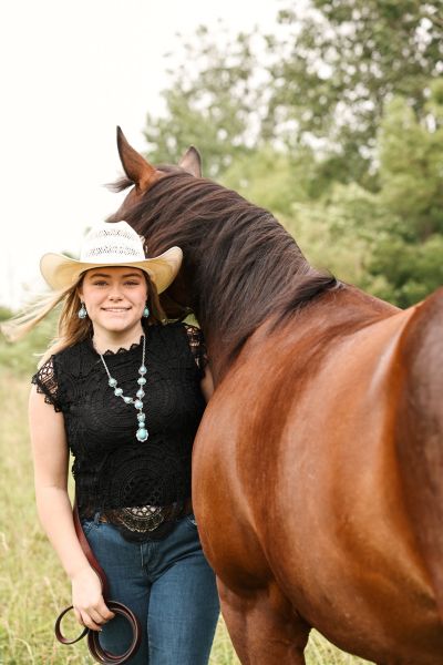 Morgan White posing with her horse.