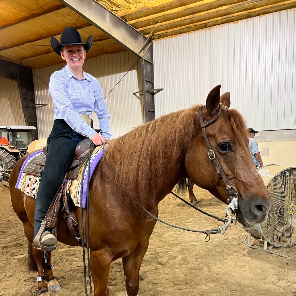 Hope Bishop riding her horse indoors