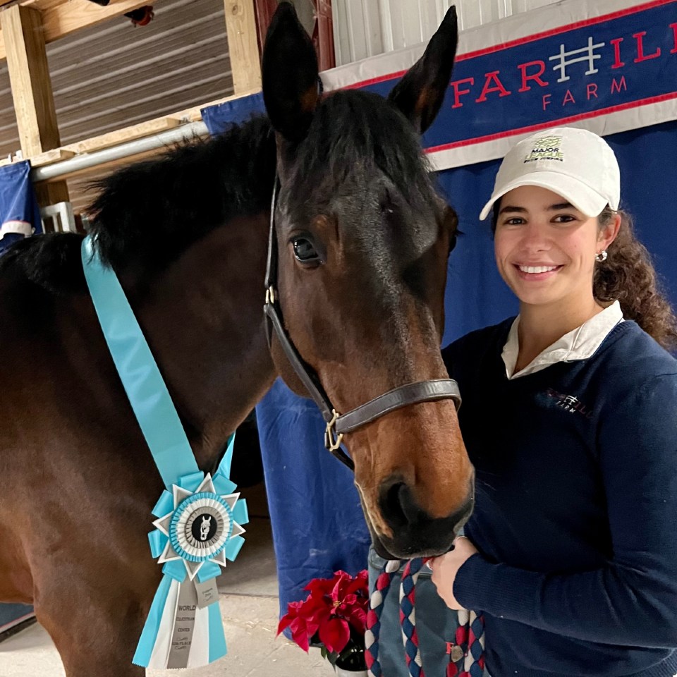 Mary Roskens standing next to her blue ribbon wearing horse