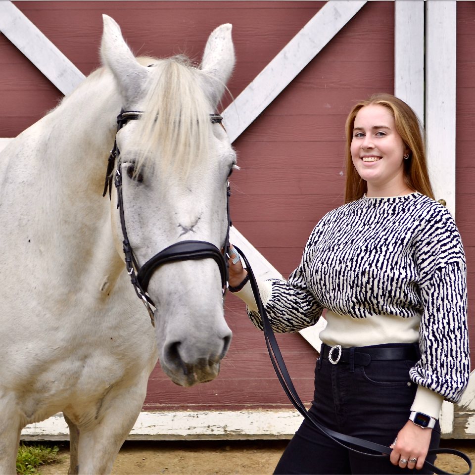 Michaela Sherlock posing with her horse outside