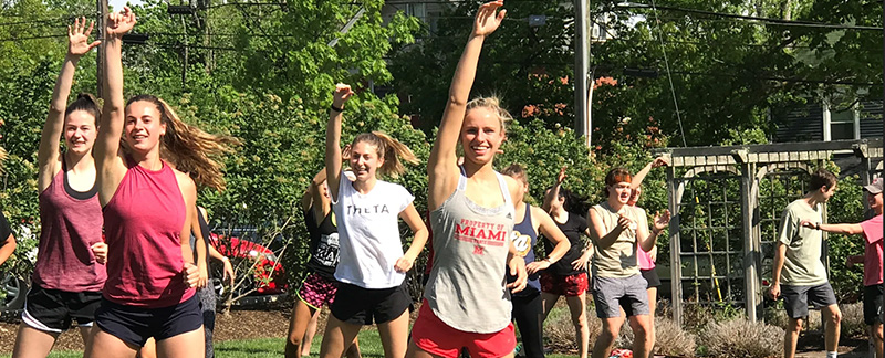 A group of Miami students taking an aerobics class outside