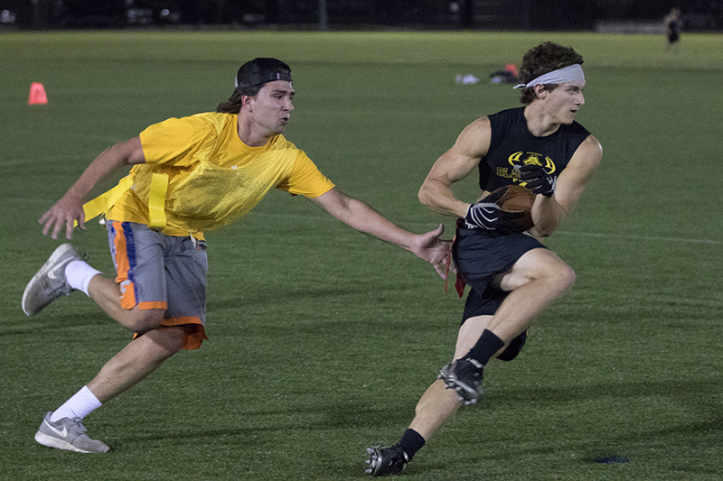 Intramural flag football player avoiding defender