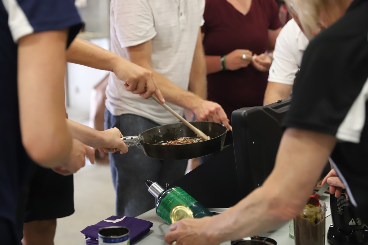 student cooking food on a pan