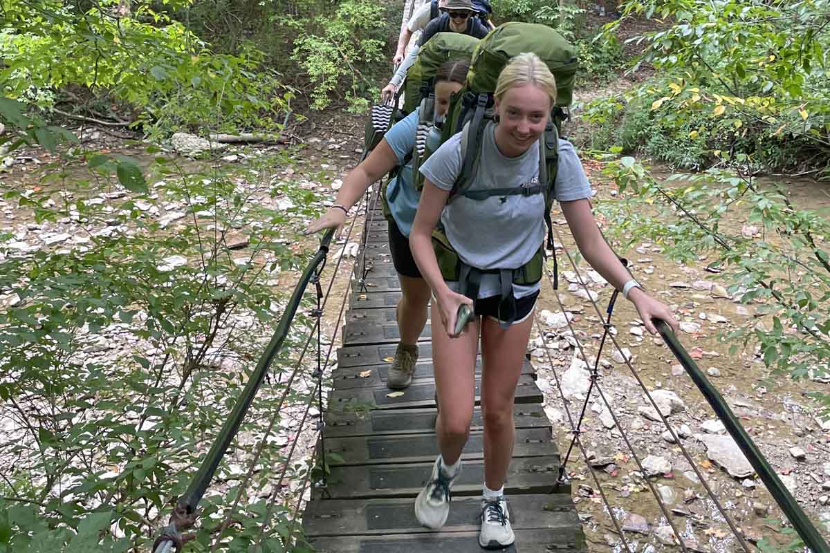 Person backpacking through some dense woods