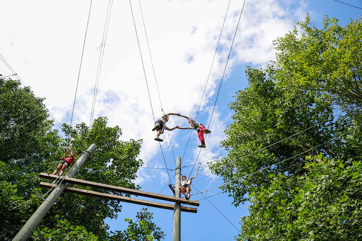 two climbers on outdoor challenge course working together