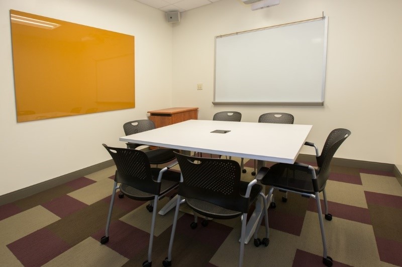 Small room with 6 chairs around a square table.