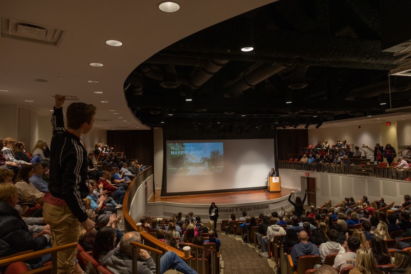 crowded 500-person stadium style theater, with a stage in front. 