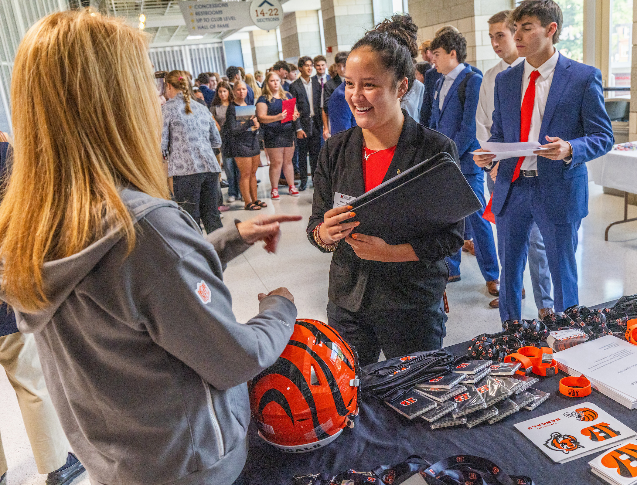 A student smiles while speaking with a Bengals representative at a career fair.