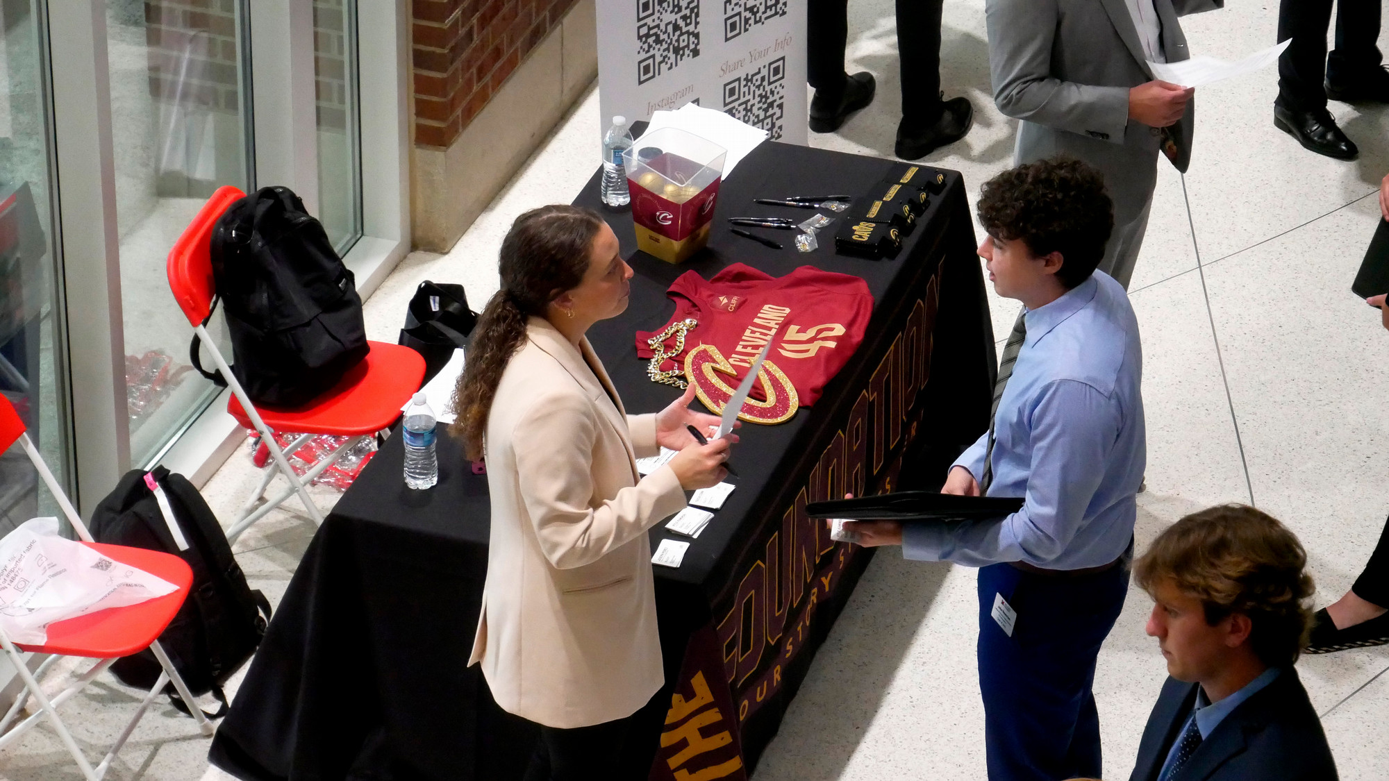 A Cleveland Cavaliers representative speaks with a student at a career fair.