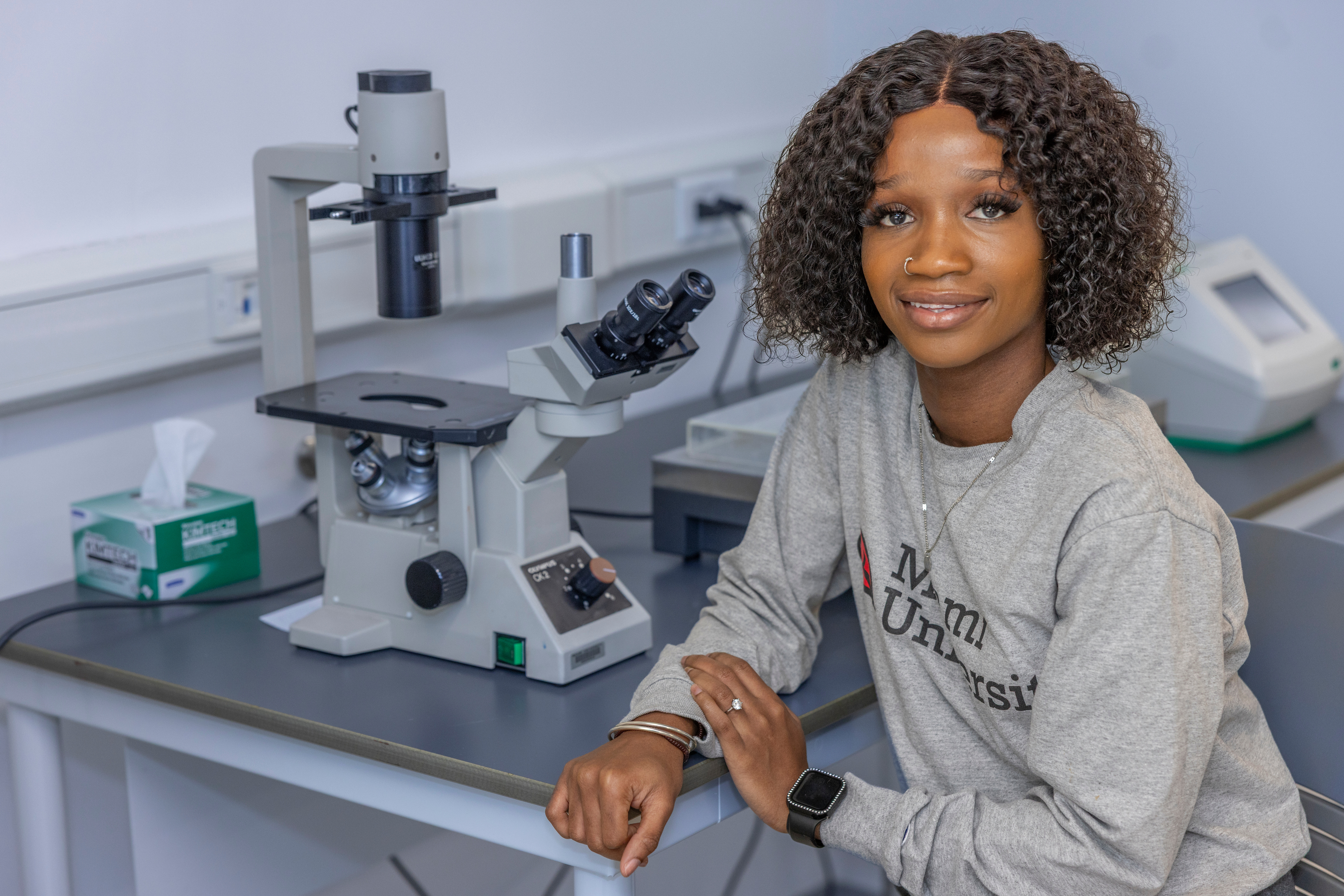 A student poses for a photo in a lab.