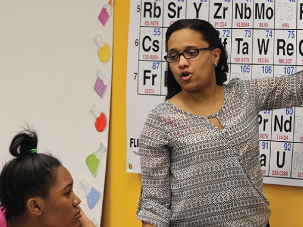 Female instructor working with a female student in a classroom.