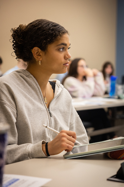 Education student intently listening to a lecture in a classroom.