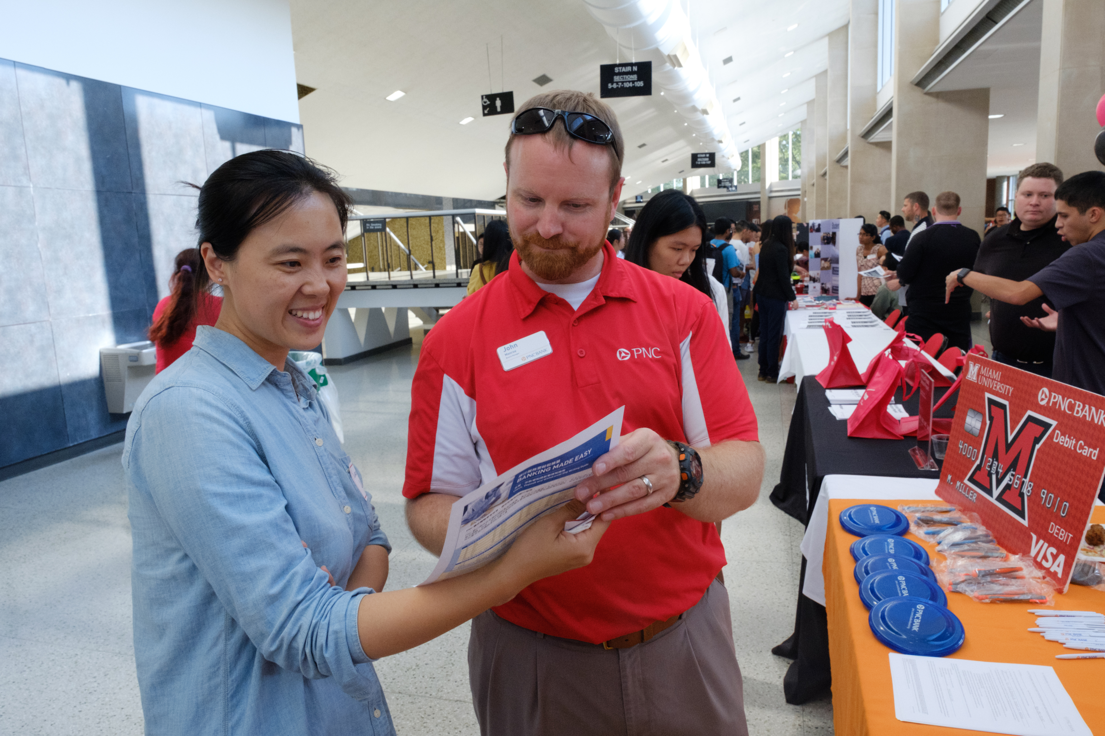 A student talks to a representative at a fair.