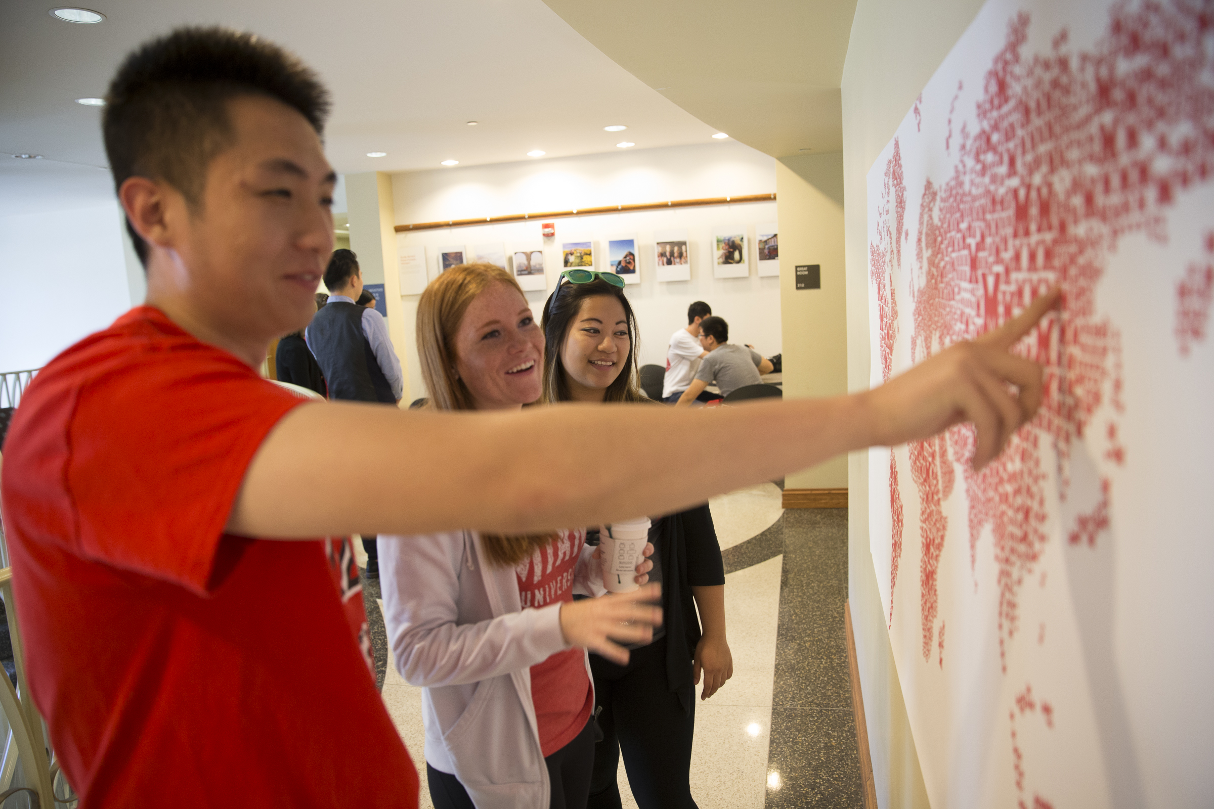 A student points at a map with red Miami logos representing it.