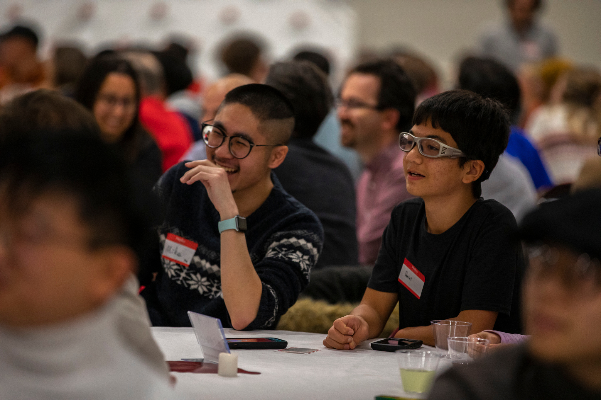 Two students smile while eating dinner at a Miami event.