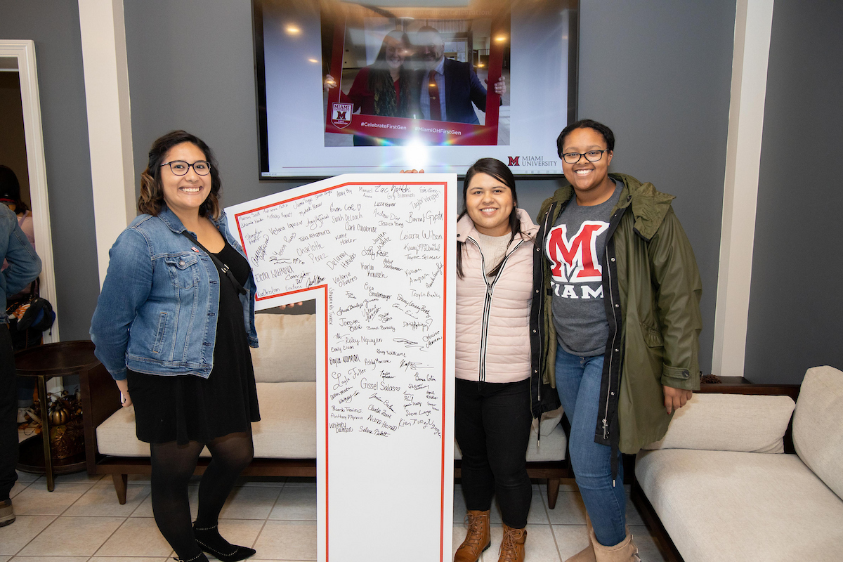 A group of students pose with the first-generation 1 sign during the National First-Generation College Student Celebration.