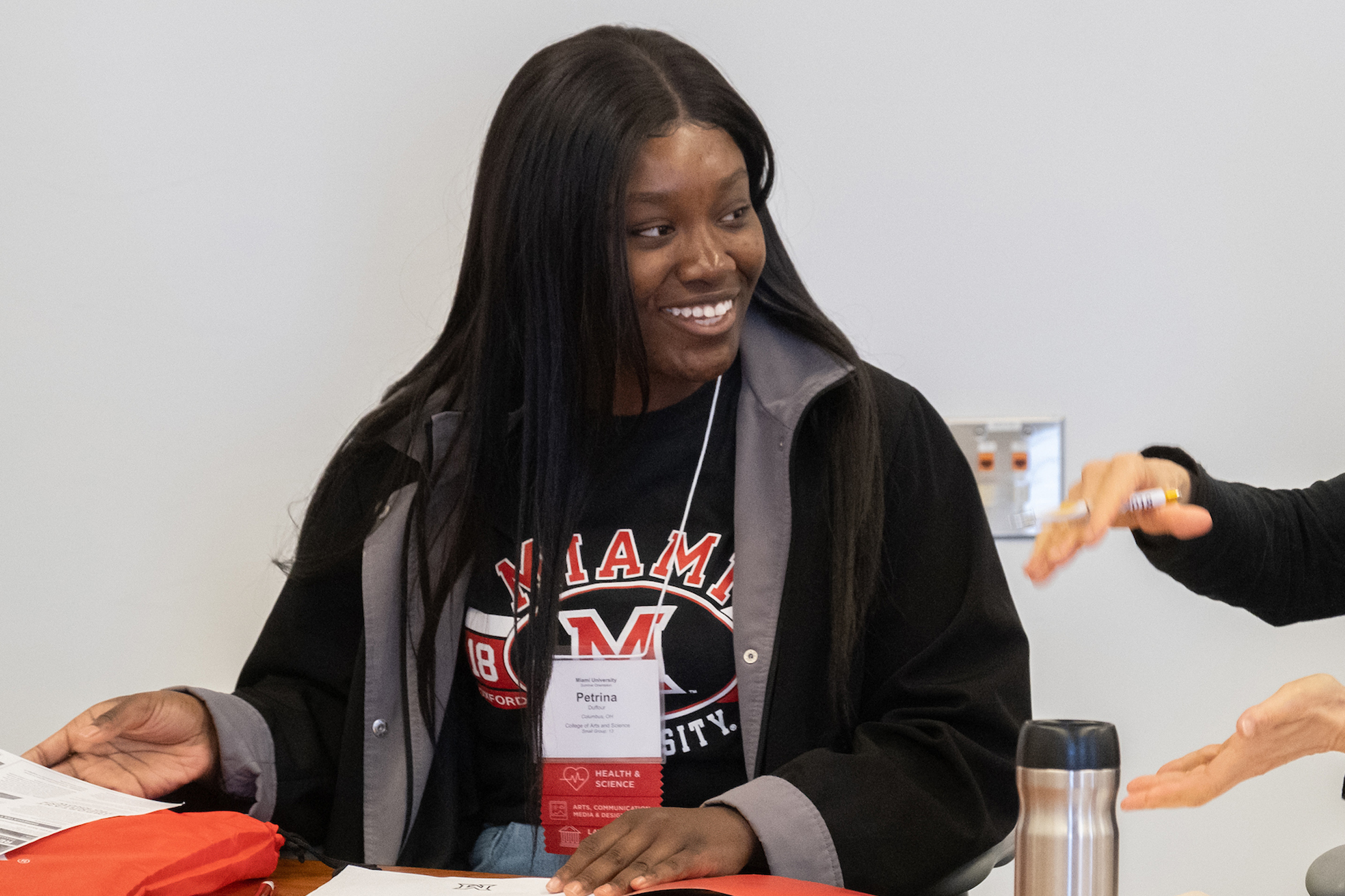 A student smiles while speaking with an advisor.