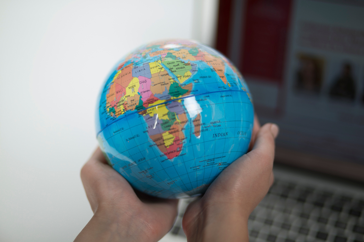 A student holds a small globe in their hands at an ISSS event.