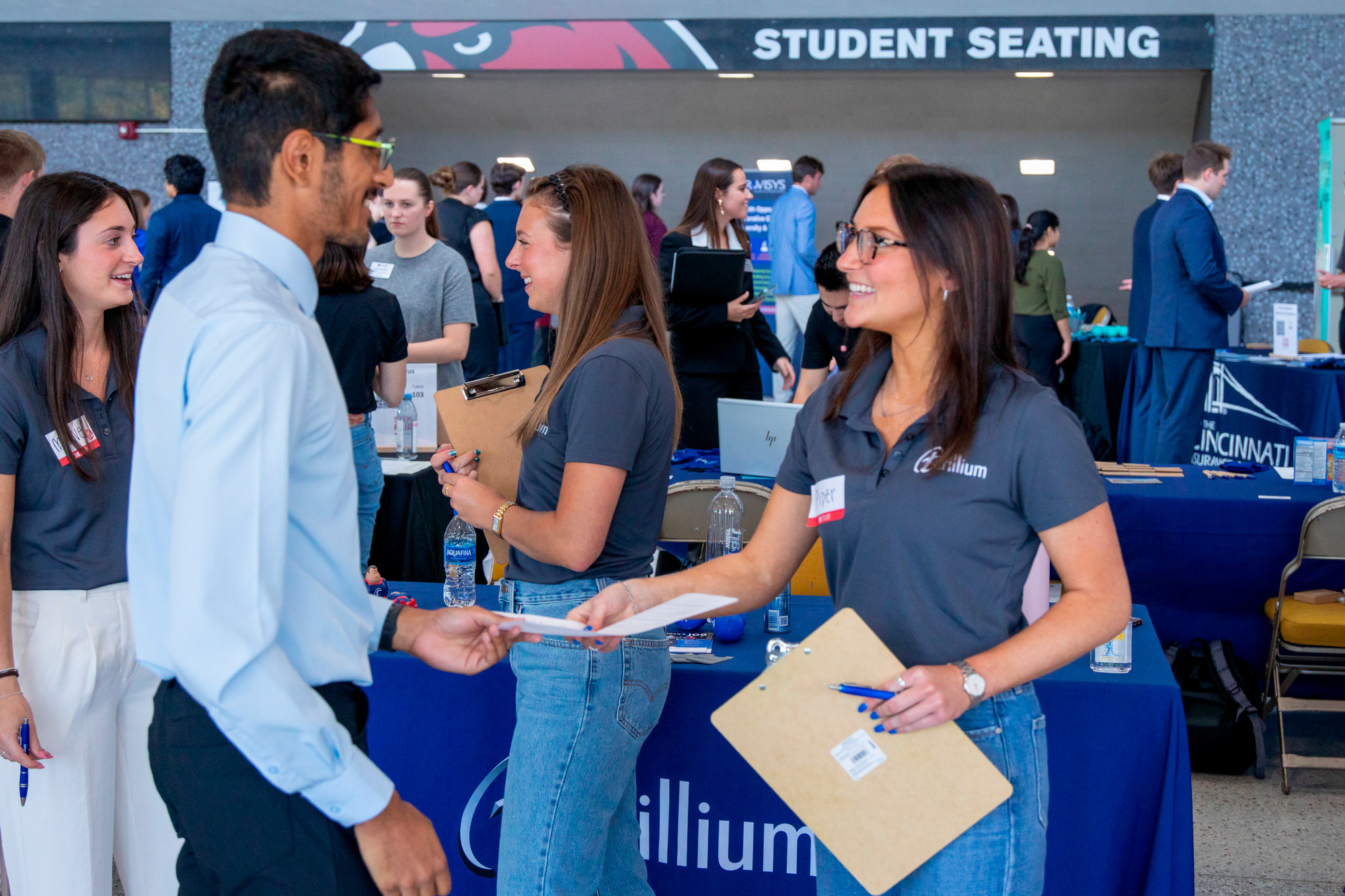 An employer shakes hands with a student at a career fair.
