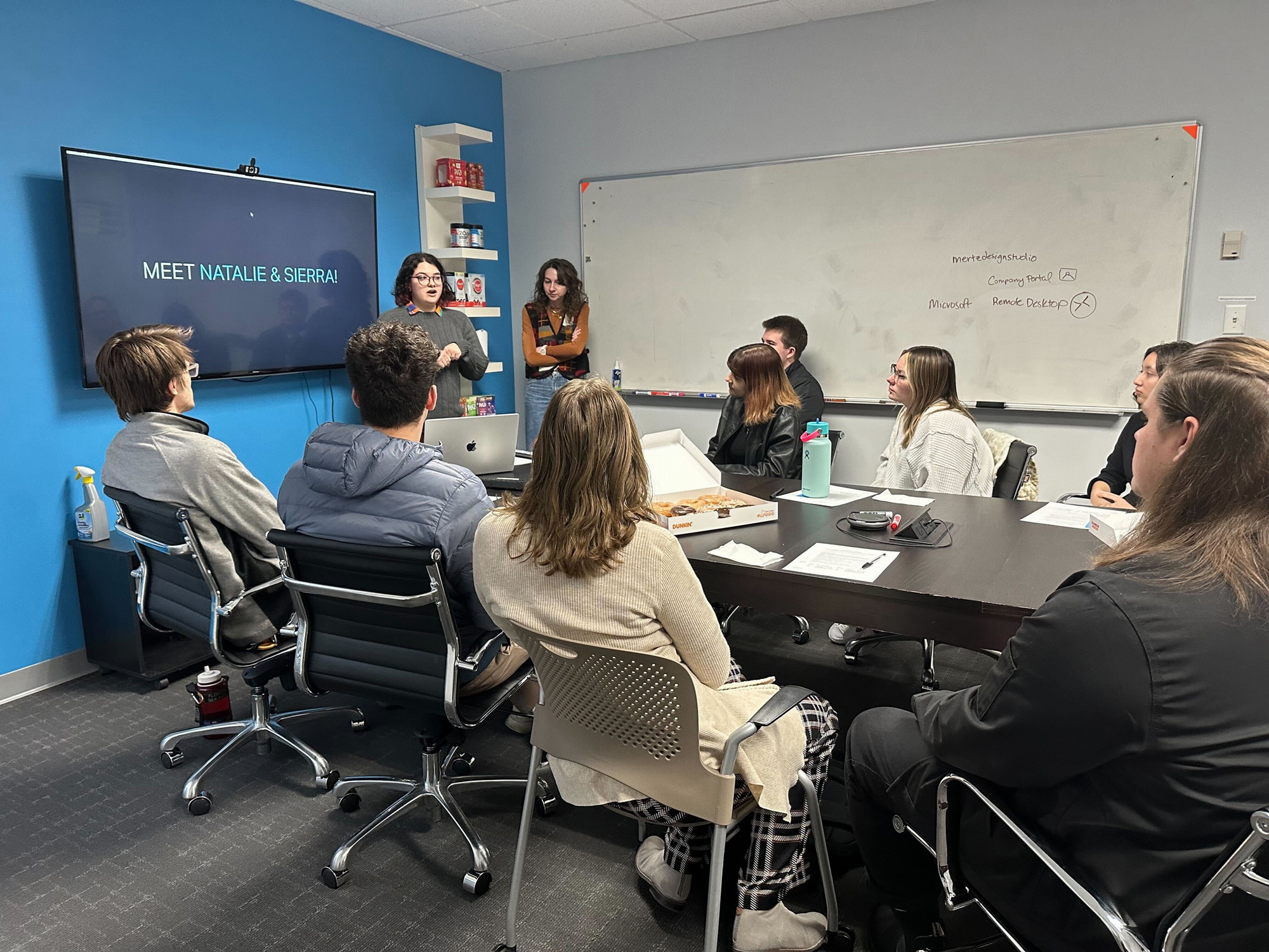 Two students present in a conference room at a job-shadow experience.