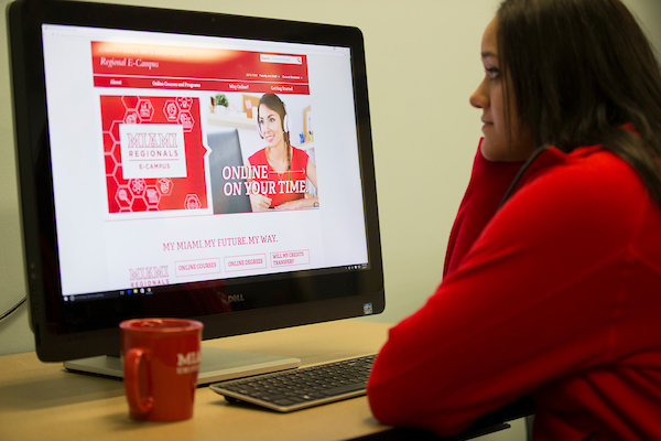 Girl looking at a website on a desktop.
