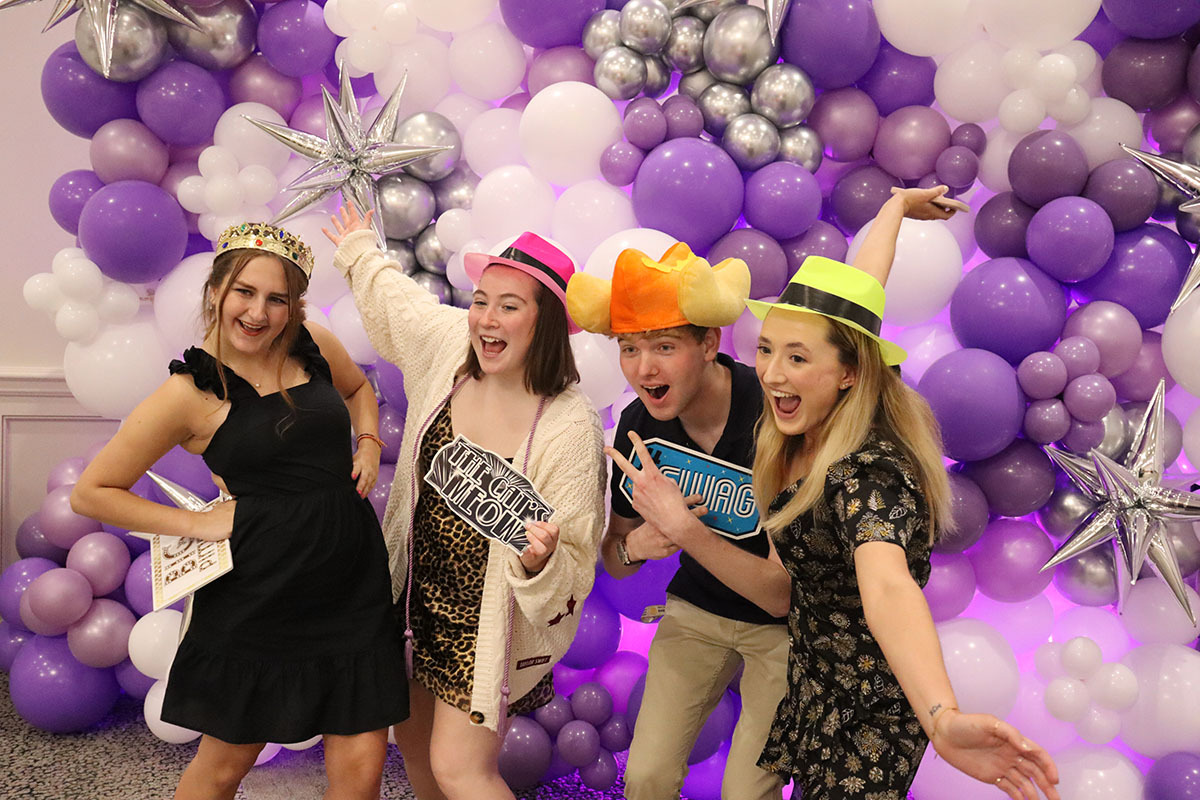 Four student posing with props.