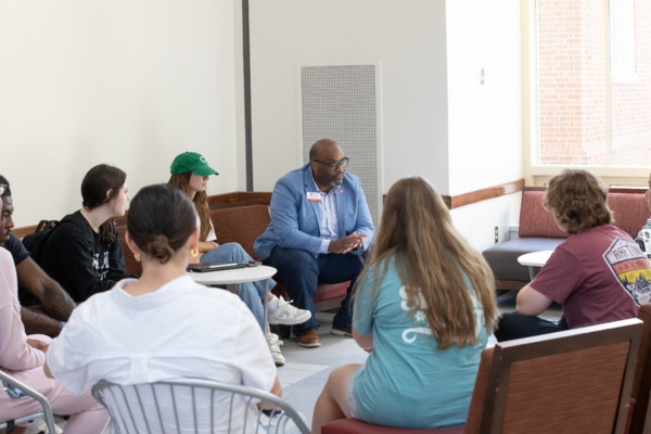 Dean BaShaun Smith talking in a circle of students.