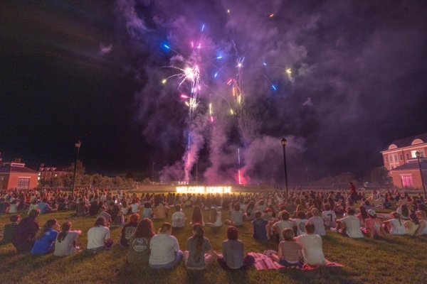 Fireworks behind Benton Hall, large crowd of students watching.