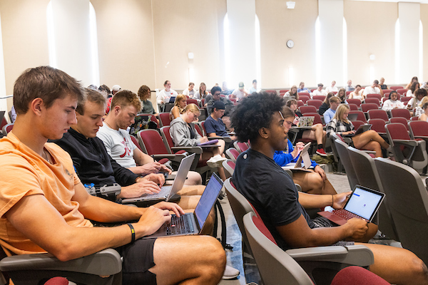 Students sit in a lecture hall for class.